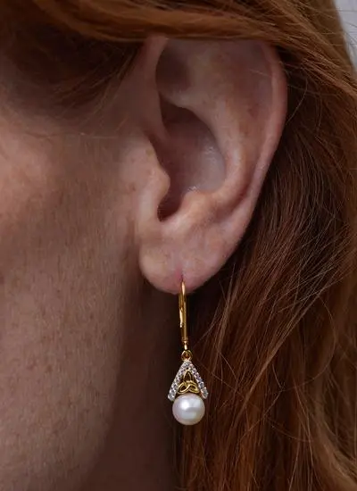 Close up shot of red haired model wearing 14Ct Gold Vermeil Pearl Celtic Trinity Knot Drop Earrings